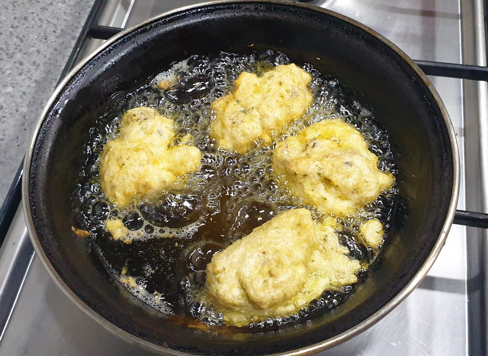 Girar los buñuelos para dorar por ambos lados